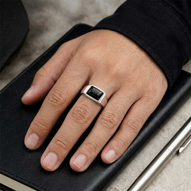 Cincin Pria Perak Bali Siver 925 Black Handmade Onyx Natural Signet Canero pada jari cowok di atas meja