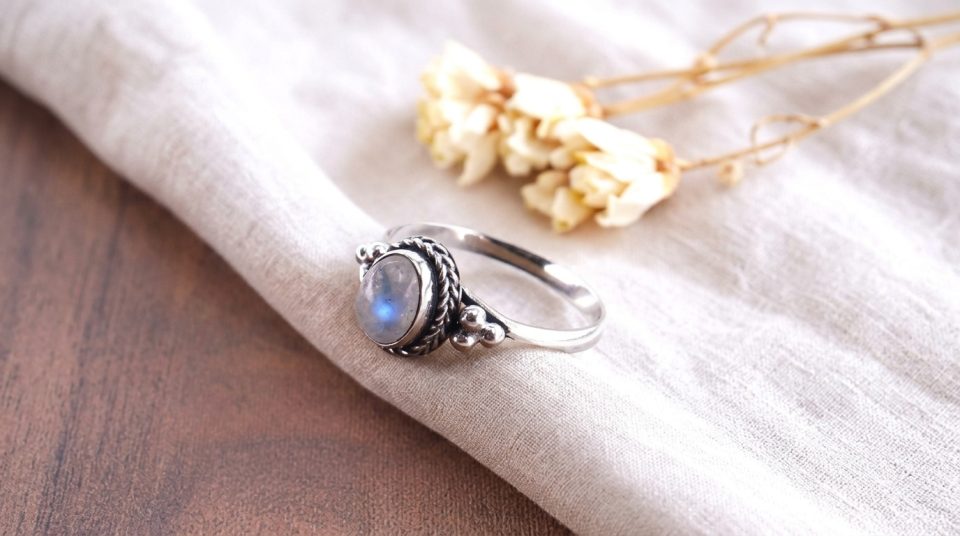 Cincin perak Bali (menonjolkan detail ukiran jawan atau filigree) yang membingkai sebuah batu Moonstone