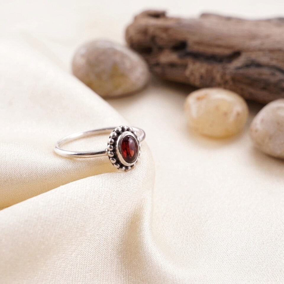 Close-up batu permata alami natural red garnet bentuk oval cabochon warna deep red.