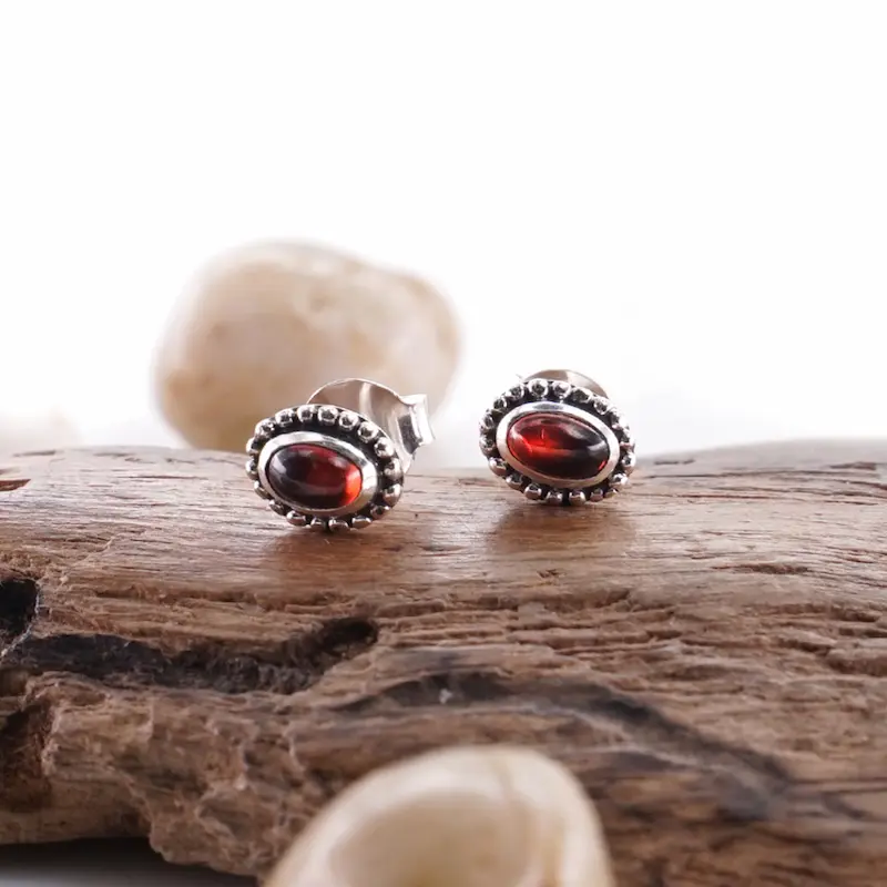 Detail seni jawan ukiran Bali pada anting perak 925 dengan permata merah.