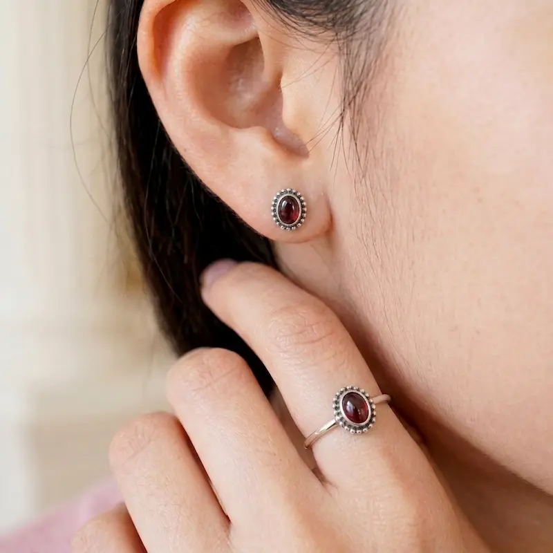 anting-perak-925-batu-permata-merah-on-ear Tampilan estetis saat anting perak 925 batu permata merah dipakai di telinga model wanita.